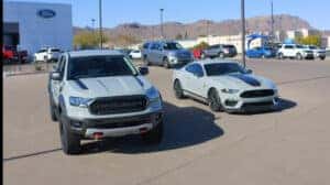 a light gray pickup and light gray Mustang