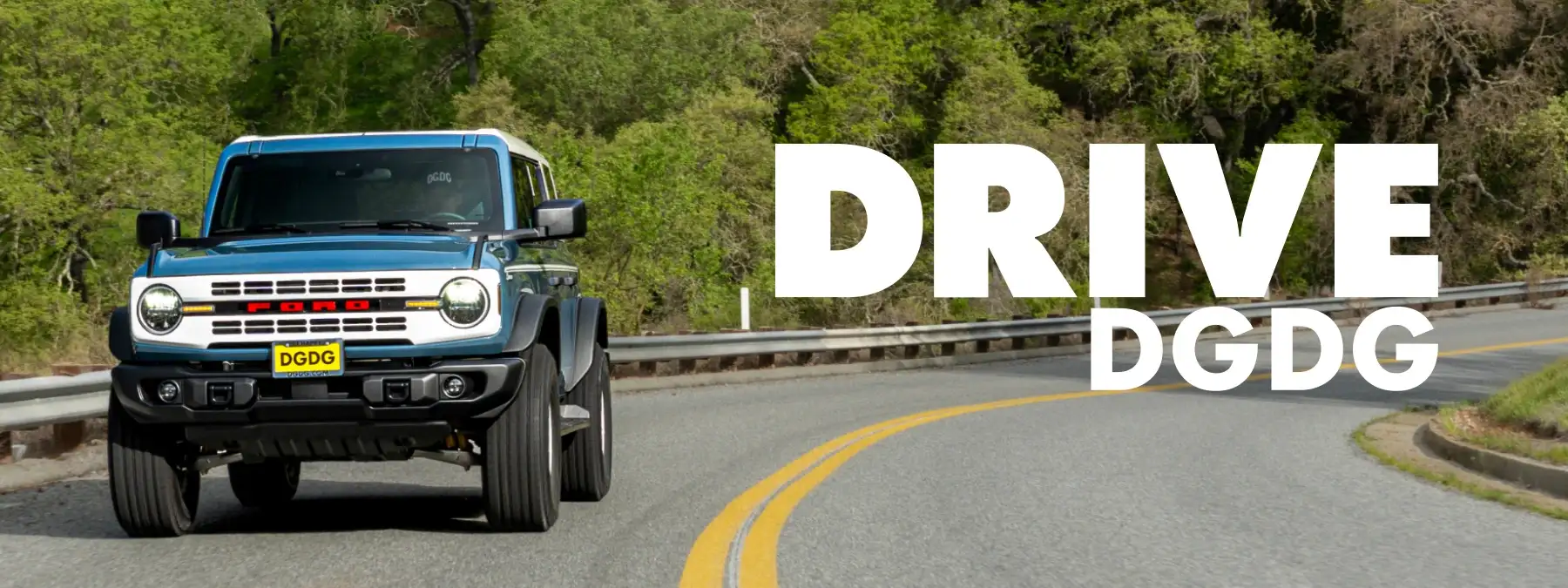 Blue and white Ford Bronco Heritage Edition driving on a road with 'DRIVE DGDG' hero text overlay.