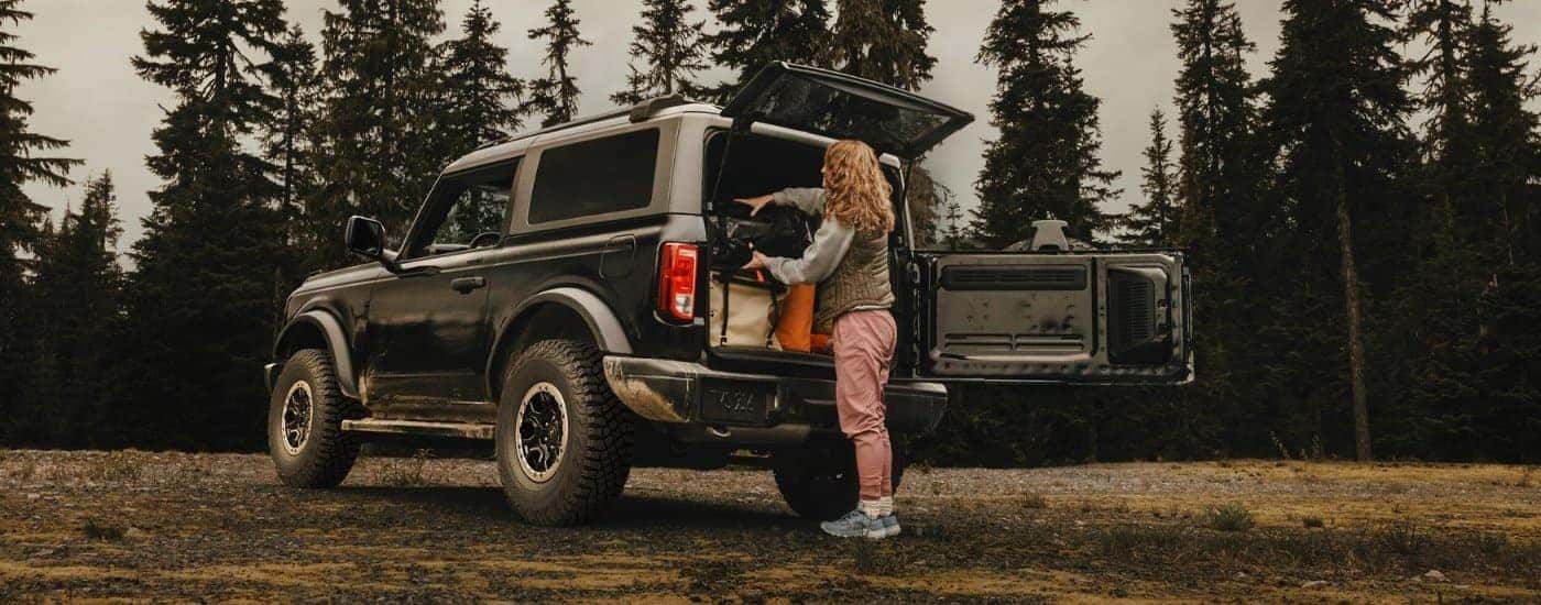 Person loading gear into a black 2025 Ford Bronco