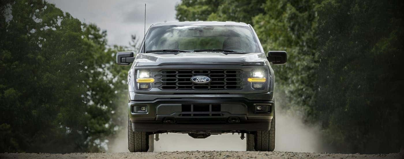 Black 2026 Ford F-150 driving up a trail