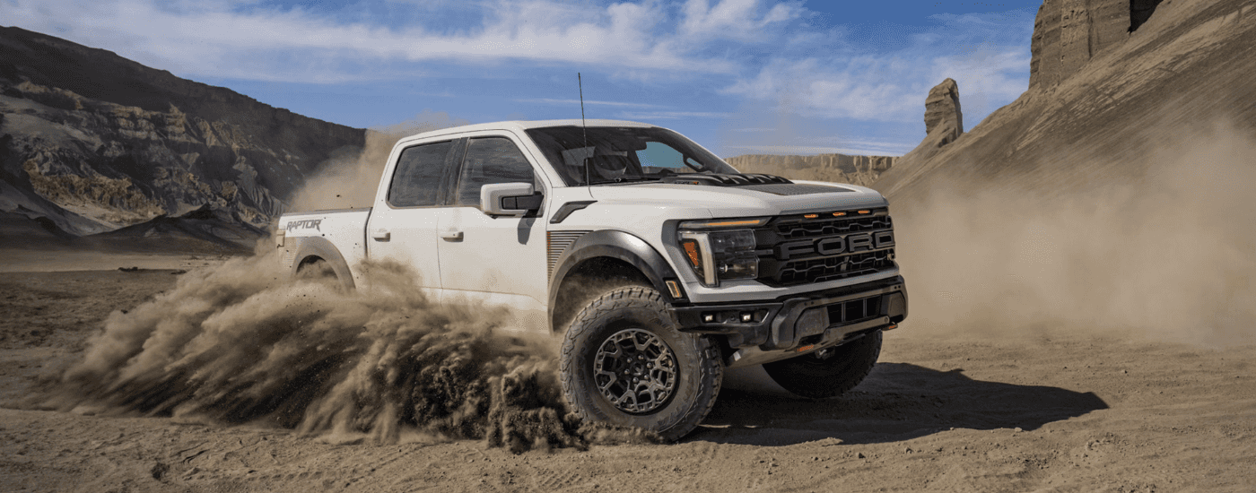 White 2026 Ford F-150 Raptor drifting in sand