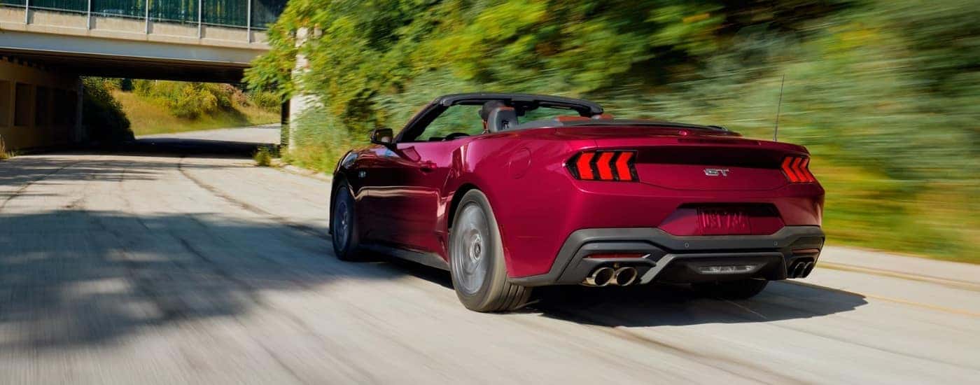 Red 2026 Ford Mustang GT driving to a Ford dealer