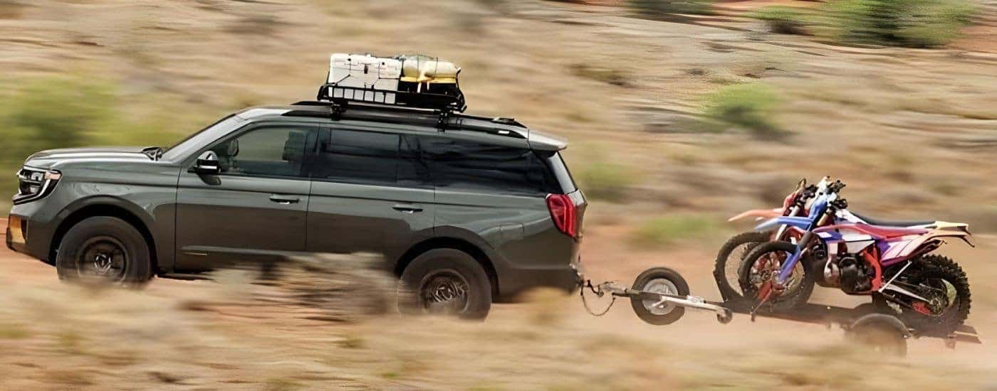 A green 2025 Ford Expedition Tremor is shown driving off-road.