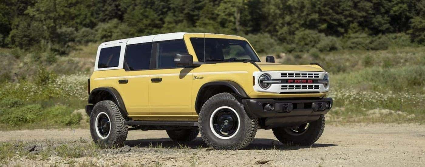 A yellow 2024 Ford Bronco Heritage Limited Edition shown parked in a field.