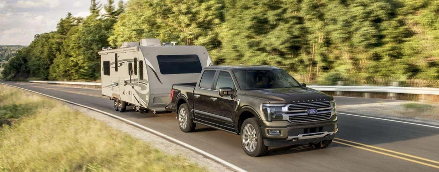 A black 2026 Ford F-150 towing a trailer.