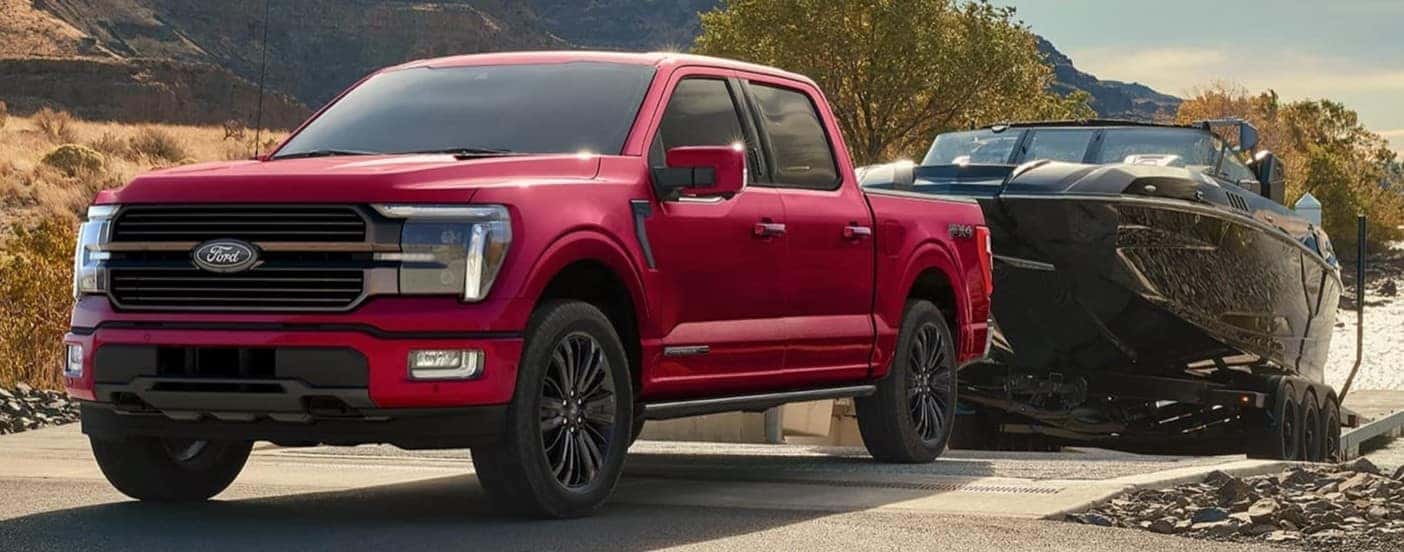 A red 2026 Ford F-150 towing a boat.