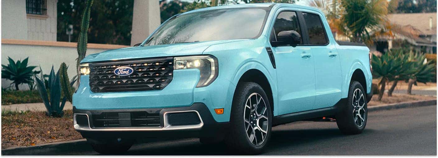 Light blue 2026 Ford Maverick pickup truck parked along a residential street.