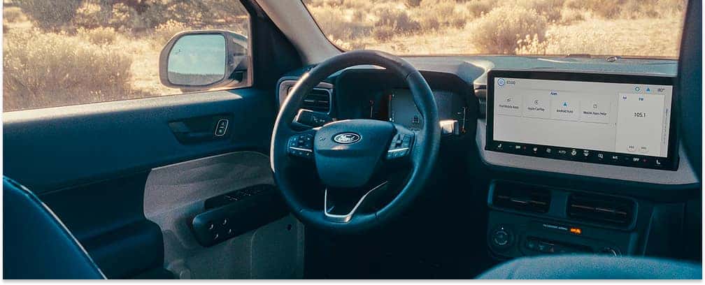 Interior view of a 2026 Ford Maverick showing the steering wheel, digital dashboard, and center touchscreen.