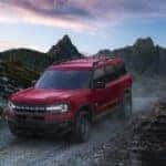 A red 2021 Ford Bronco Sport Big Bend Edition is driving down a rocky path after leaving a Ford Bronco dealer in Canon City.