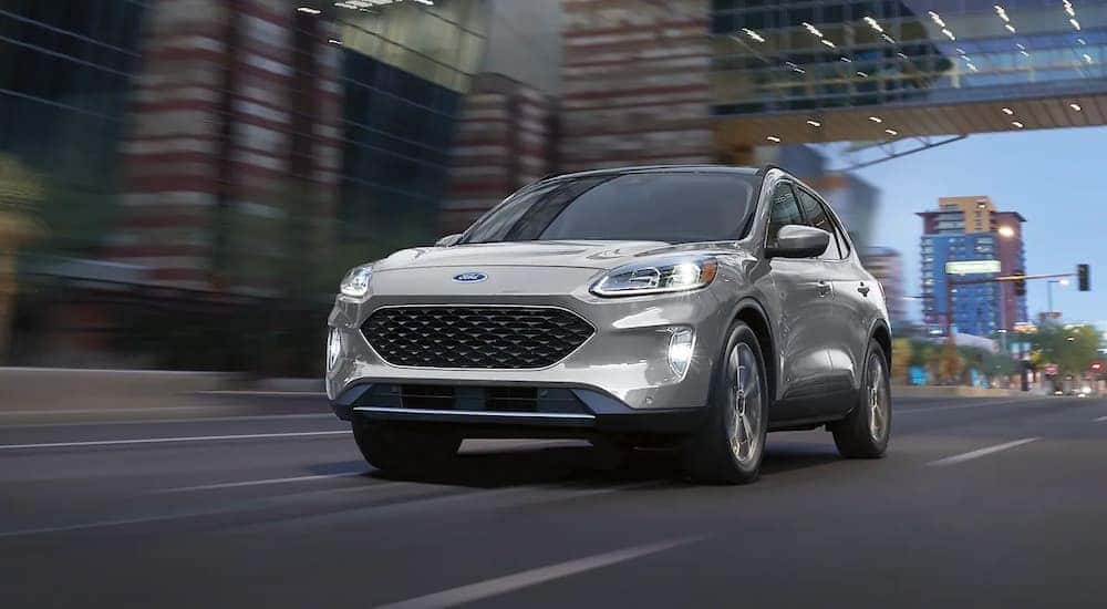 A silver 2020 Ford Escape Hybrid Titanium driving on a city street after visiting a Colorado Ford Escape dealer.