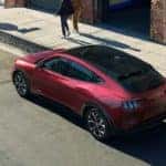 A red Ford Mustang Mach-e, seen from above, parked on a city street