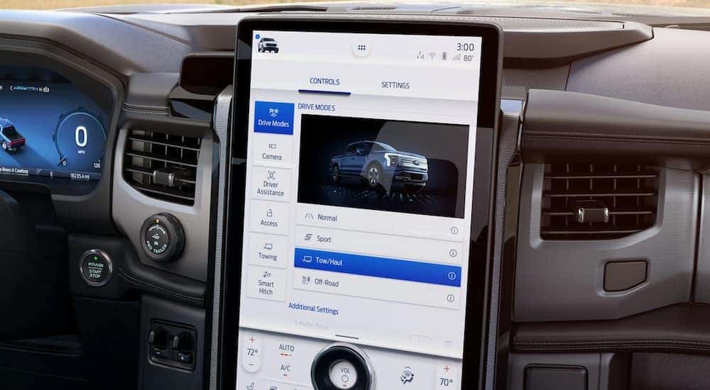 Interior view of a 2022 Ford F-150 Lightning with oversized infotainment screen showing advanced vehicle controls.