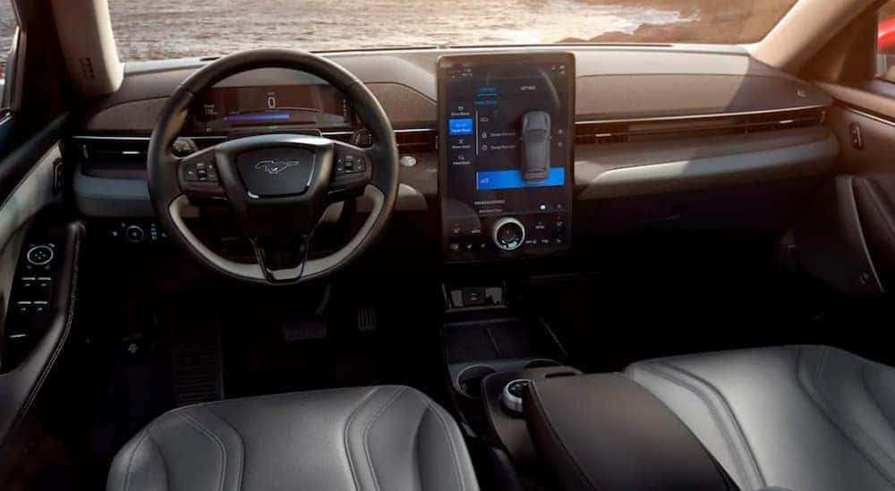 The black leather interior of a 2021 Ford Mustang Mach-E with large infotainment screen.