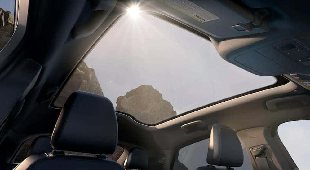 View of sun and mountains through the glass roof of a Ford Mustang Mach-e