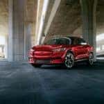 A red Ford Mustang Mach-e Mustang parked under an overpass