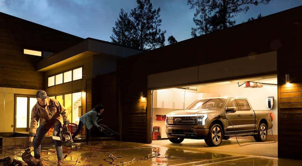 A silver 2022 Ford F-150 Lightning powering a home after a storm.