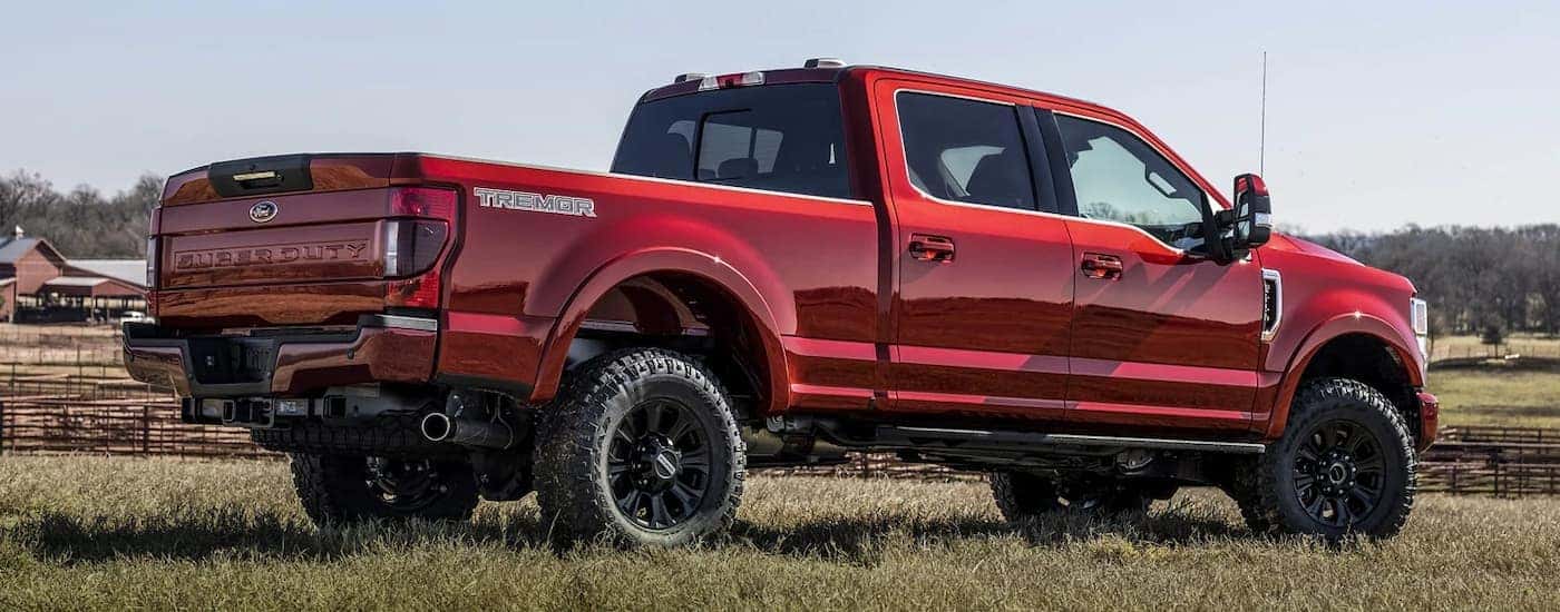 A red 2022 Ford F-250 Super Duty Lariat Tremor is shown on the grass after visiting a Pueblo Ford Super Duty dealer.