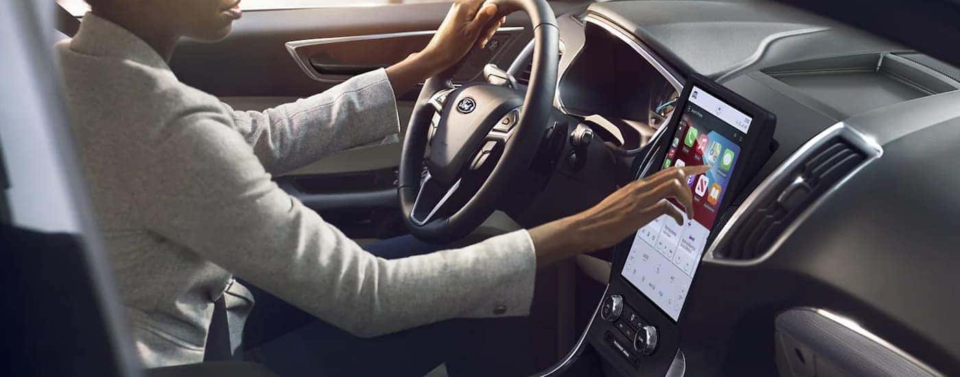 A woman is shown sitting in the driver's seat of a 2022 Ford Edge.