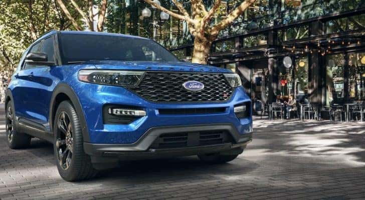 A blue 2022 Ford Explorer ST is shown parked outside of a storefront.