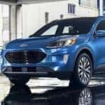 A blue 2021 Ford Escape Titanium is shown parked at a Pueblo used car dealer.