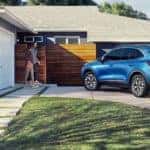 A blue 2022 Ford Escape is shown from the rear while parked in front of a house after leaving a Ford Escape dealer.