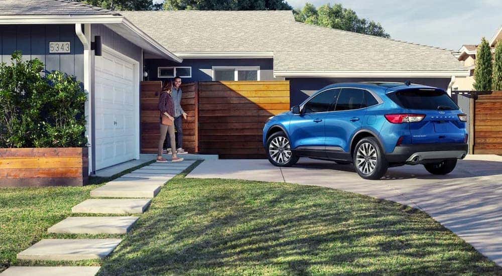 A blue 2022 Ford Escape is shown from the rear while parked in front of a house after leaving a Ford Escape dealer.
