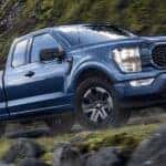A blue 2023 Ford F-150 STX is shown from the side at an angle.