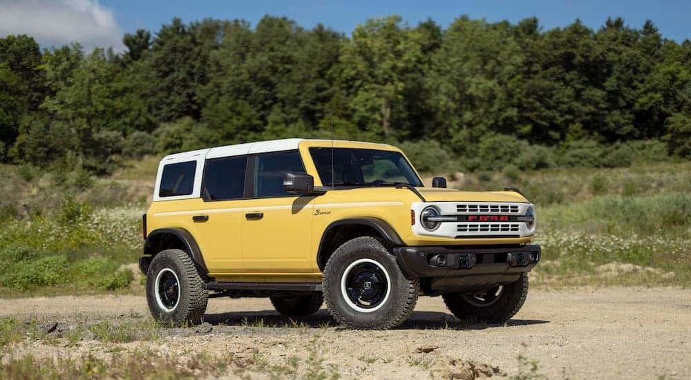 A yellow 2023 Ford Bronco Heritage Edition is shown from the side while off-road.