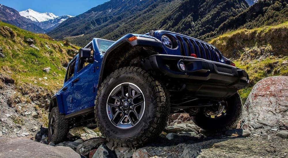 A blue 2019 Jeep Wrangler Rubicon is shown driving off-road.