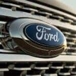 A close-up on the badge of one of the most common used SUVs for sale, a black 2021 Ford Expedition, is shown.