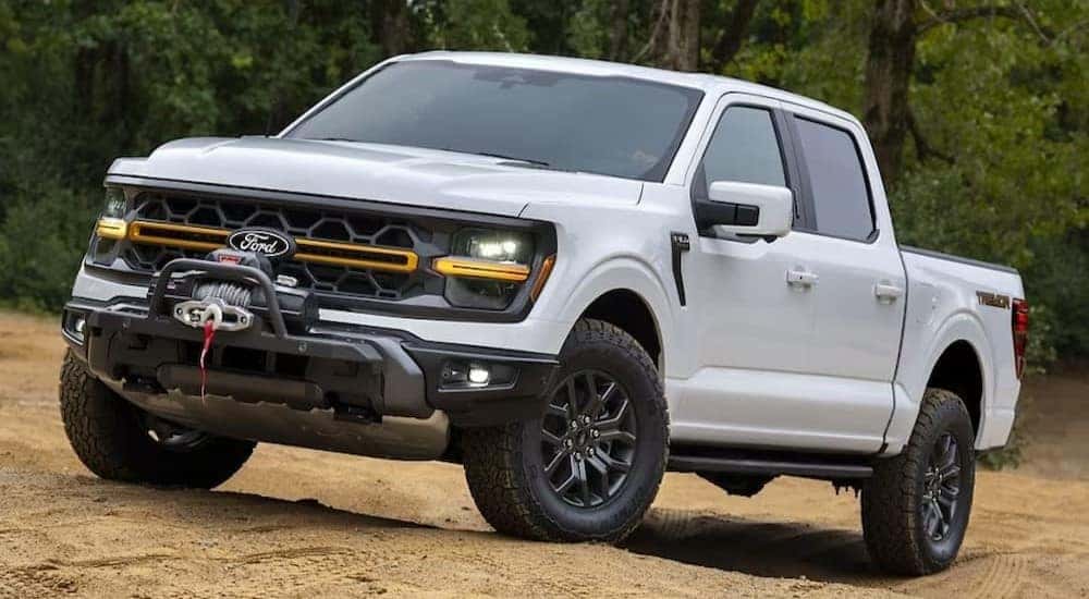 A white 2024 Ford F-150 Tremor is shown parked on sand.