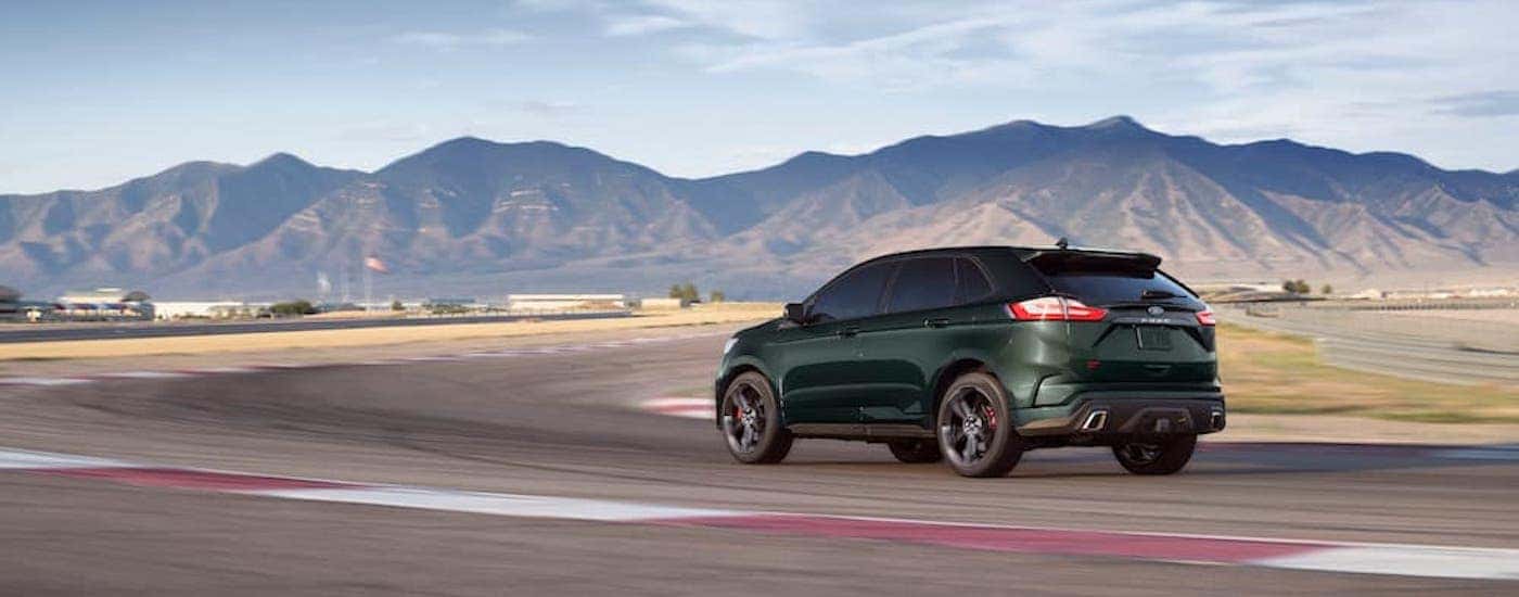 A green 2024 Ford Edge for sale near Florence is shown from the rear at an angle.