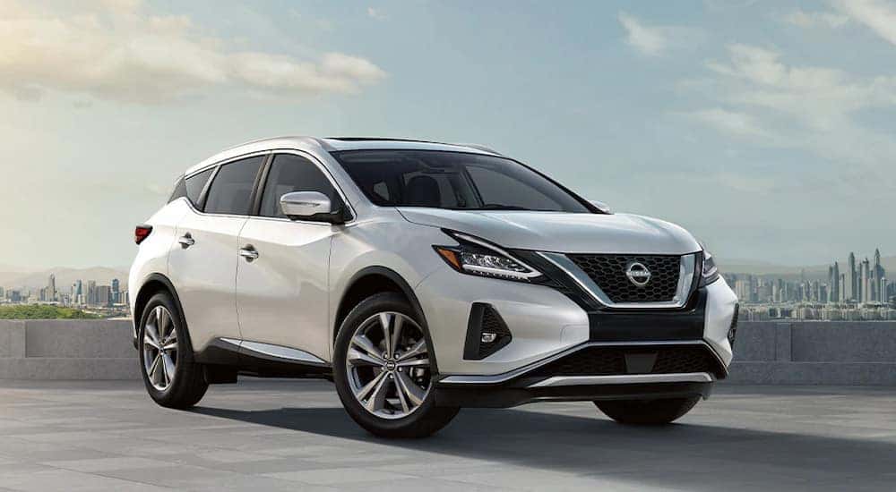 A white 2024 Nissan Murano Platinum with a city in the background.