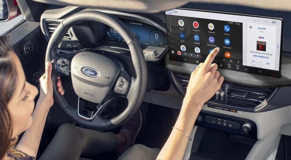 A person is shown touching the infotainment screen in a 2024 Ford Escape.