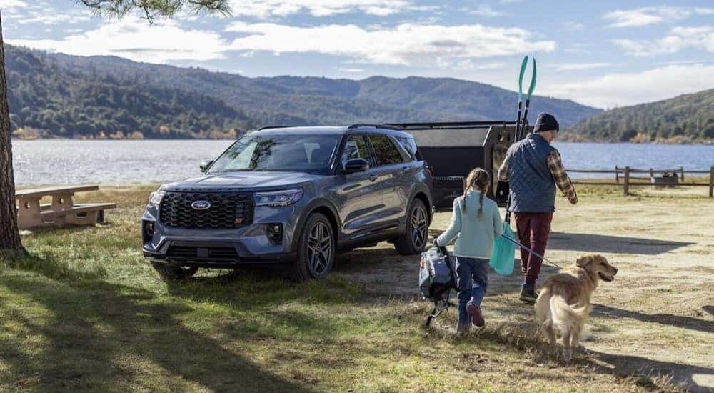 A blue 2025 Ford Explorer ST is shown parked near a lake.
