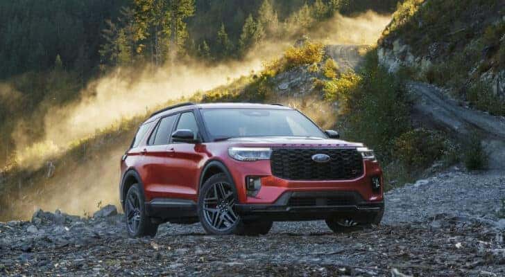 A red 2025 Ford Explorer ST parked in a clearing.