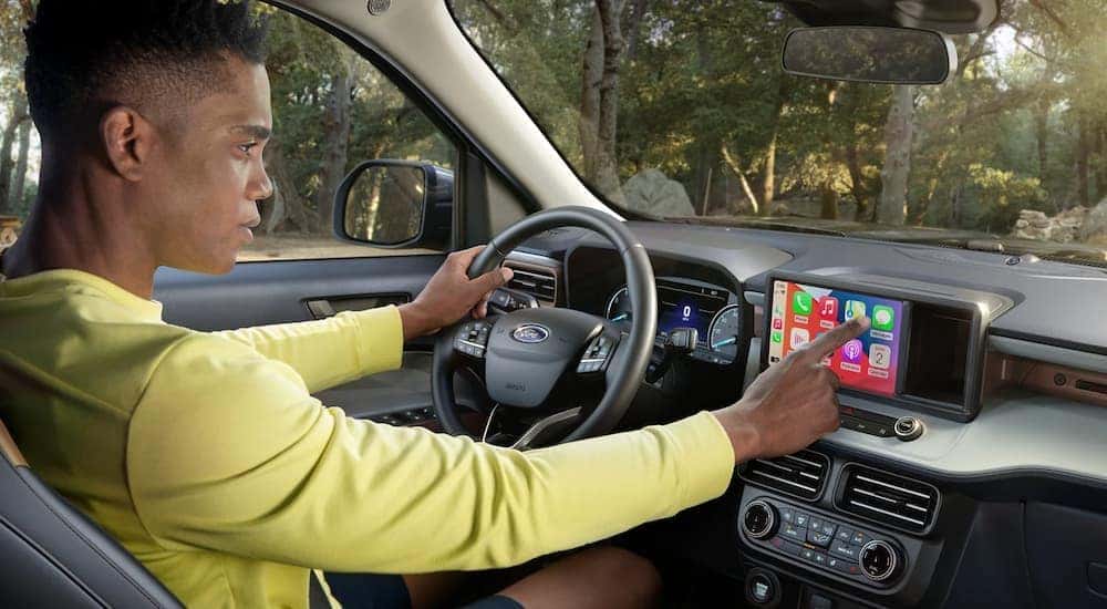 A man is using the infotainment screen in a 2024 Ford Maverick.