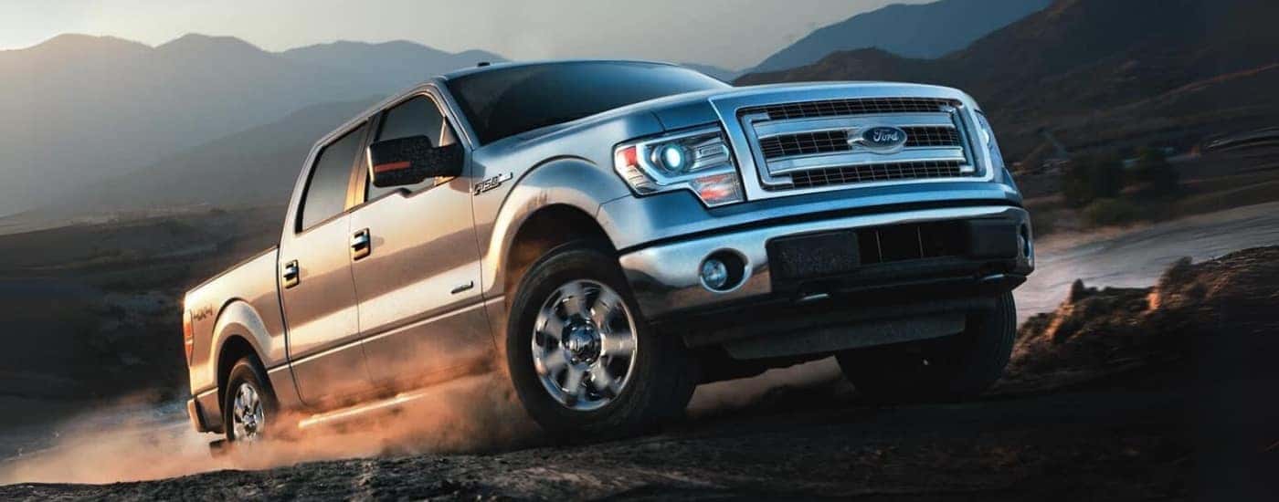 A silver 2014 Ford F-150 is shown off-road.