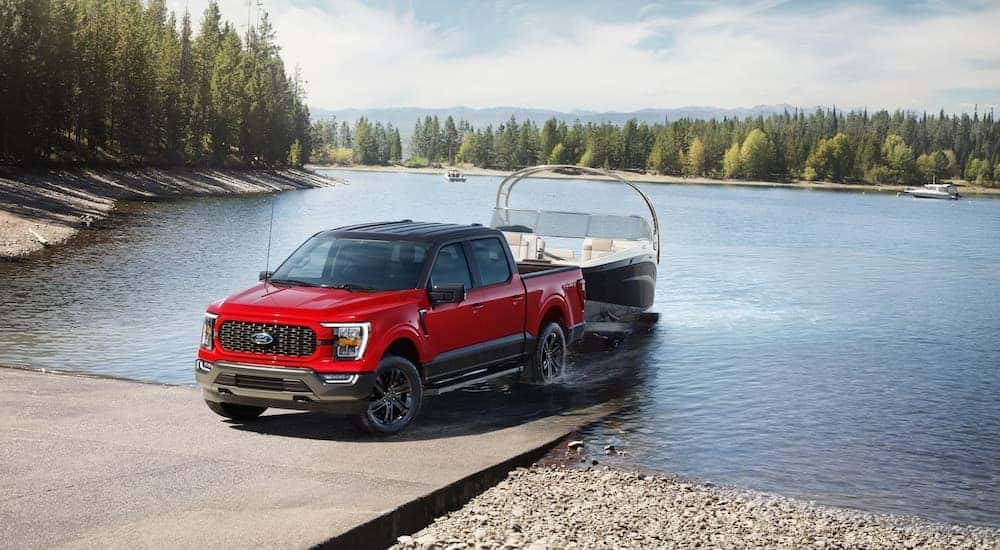 A red 2023 Ford F-150 XLT Heritage Edition is shown from the front while loading a boat.