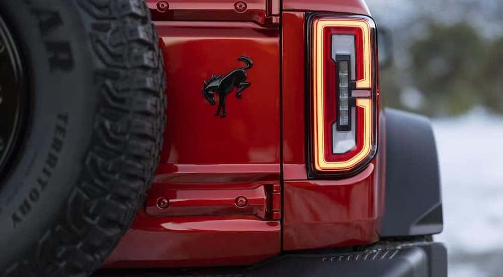 A close-up of a tail light is shown on a red 2024 Ford Bronco Wildtrak.
