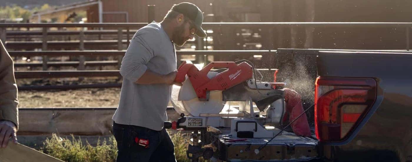 A man using power tools in the bed of a 2024 Ford F-150 for sale near Pueblo.