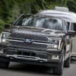 A black 2025 Ford F-150 Platinum Plus towing a trailer from a dealer with a Ford F-150 for sale near Pueblo.