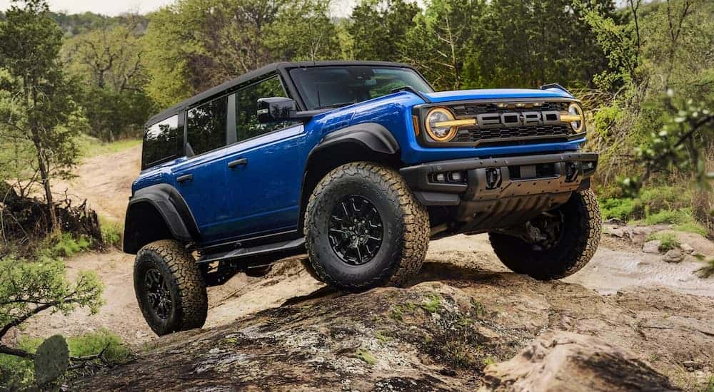 A blue 2025 Ford Bronco Raptor parked off-road on a hill.