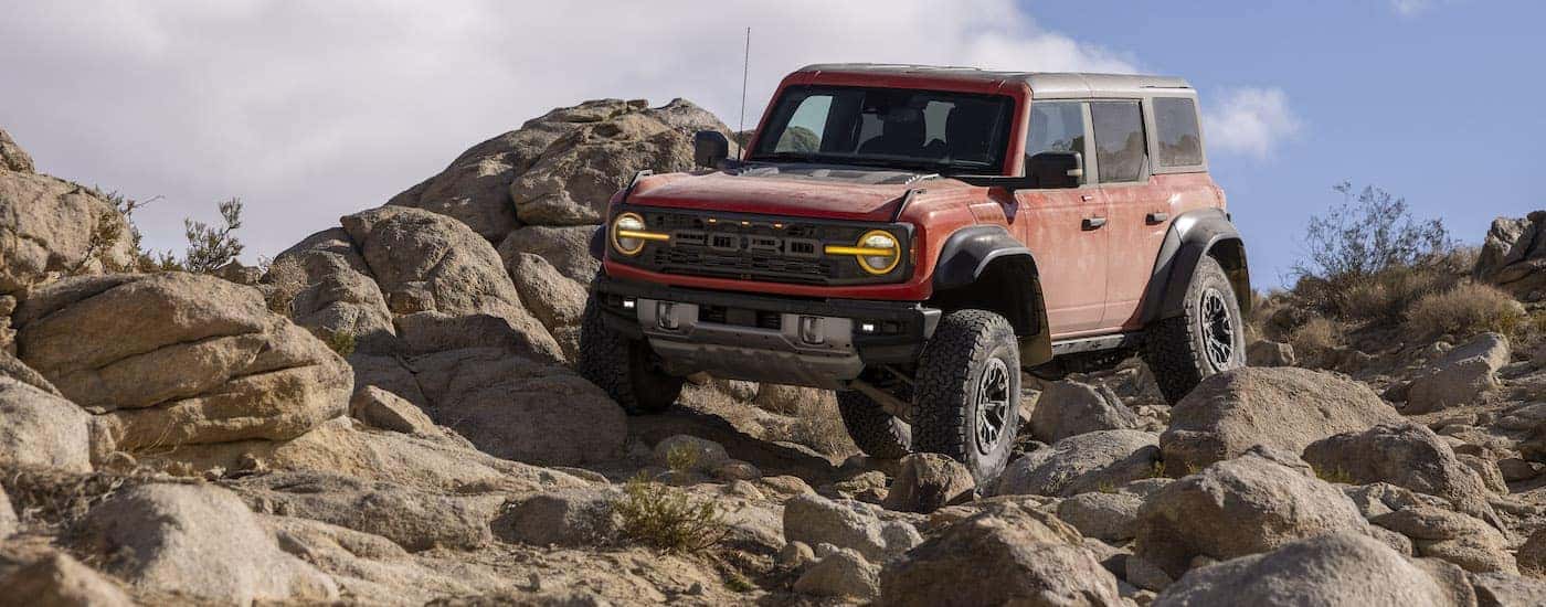 A red 2025 Ford Bronco Raptor is shown from the front at an angle.