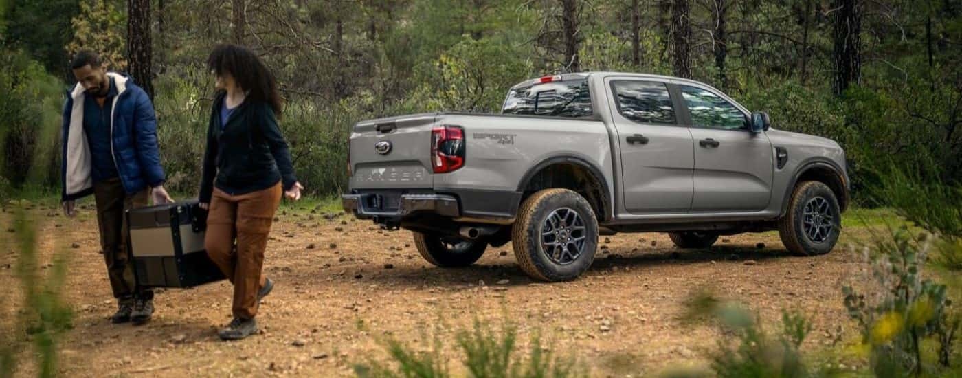 Rear view of a grey 2024 Ford Ranger Sport XLT parked off-road.