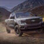 A gray 2025 Ford Ranger for sale is shown driving on a dirt path