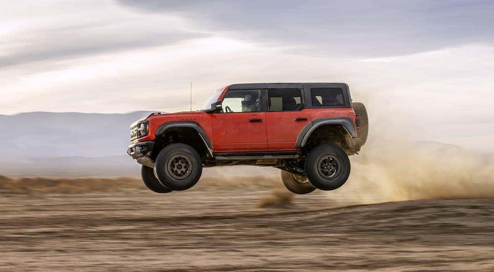 A red 2025 Ford Bronco Raptor from the side.