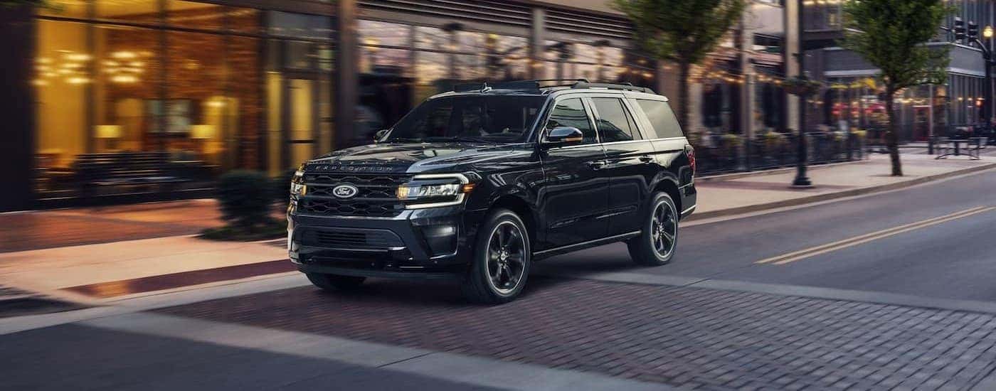 A black 2024 Ford Expedition driving to view used cars for sale near Pueblo West.