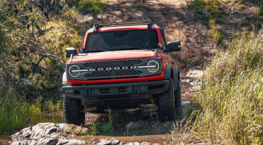 A red 2021 Ford Bronco Sport off-roading in mud