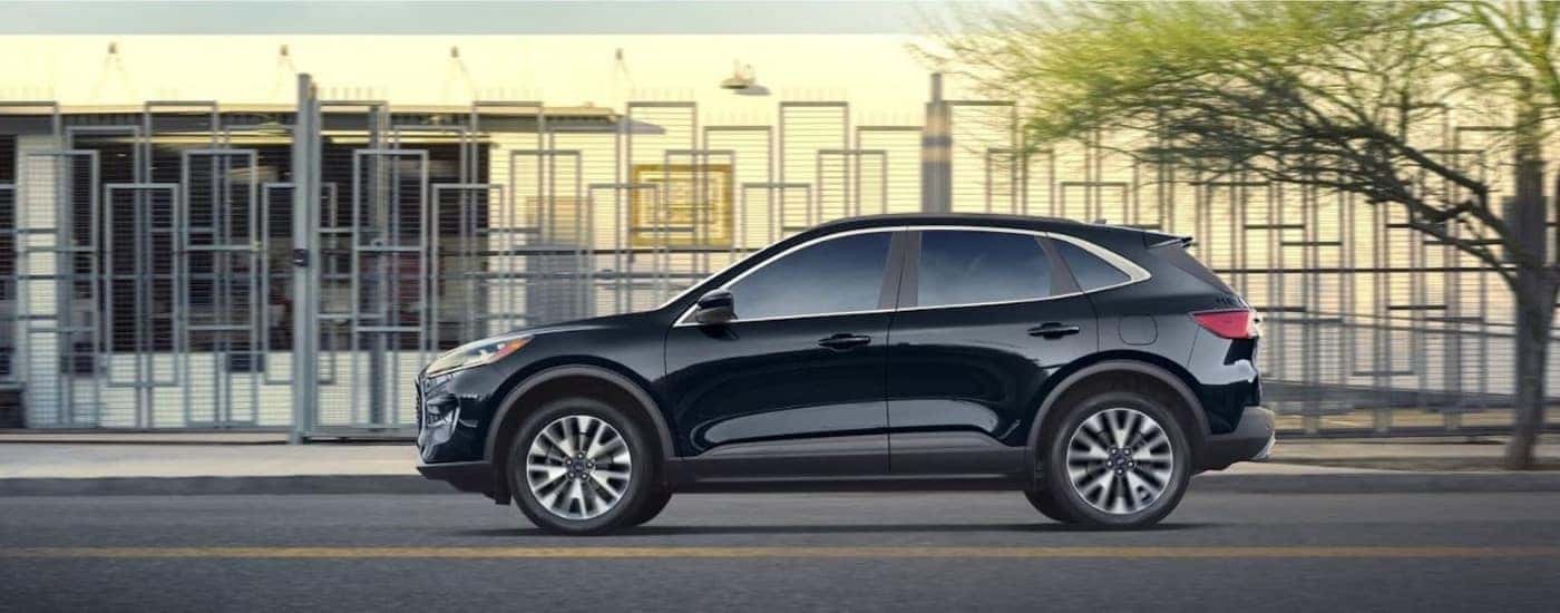 A black 2022 Ford Escape from the side after leaving a used car dealer.